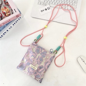 Detail of floral jacquard mini crossbody bag with adjustable pink rope shoulder strap