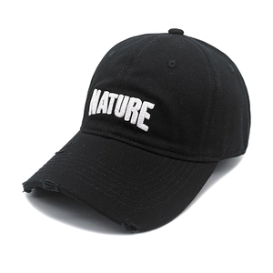 Detailed close-up of a black baseball cap featuring distressed edges and white Nature embroidery