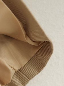 Detail of khaki jacket showing ribbed knit cuffs and smooth inner lining texture