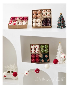 Detail of handcrafted felt wool balls in kraft box with festive patterns and rustic twine