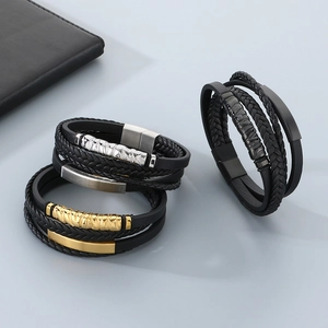 Close-up of multilayer braided leather bracelets with gold and silver metal clasps