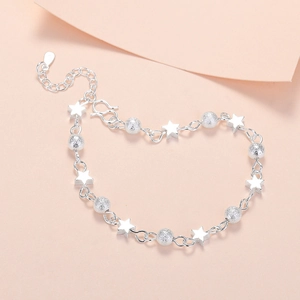 Minimalist silver planet bracelet with star beads and frosted balls on pink background