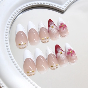 Elegant pearl white almond press-on nails with 3D embossed flowers and pearl accents