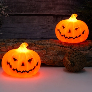 Halloween orange LED jack-o'-lantern party lamp glowing on dark wood background