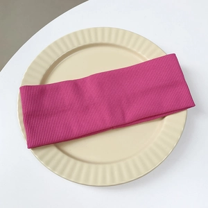 Close-up of rose red knitted ribbed headband showing stretch texture and fabric detail