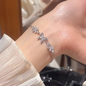 Detailed view of silver butterfly bracelet with sparkling zircon stones on a female wrist