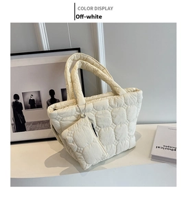Detail of cream quilted tote bag featuring cloud texture and matching coin purse