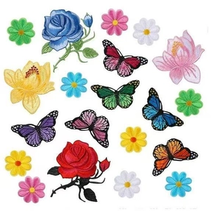Detailed view of colorful butterfly and flower embroidery patches set on white surface