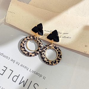 Detail view of retro leopard print hoop earrings with black geometric studs and gold rings