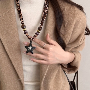 Leopard print fabric star pendant necklace with beads on a stylish beige blazer