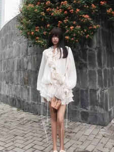 Detail of white ruffle trim and 3D floral accents on a lightweight summer outfit