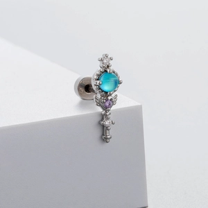 Clou d'oreille en acier titane avec zircon bleu mer et motif couronne ailée