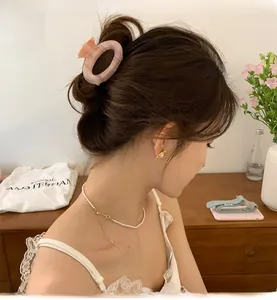 Pink marble texture acetate round hair claw clip worn by a model in a warm setting