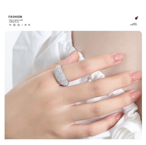 Detail of wide sparkling pave-set crystal ring on finger with fashion typography