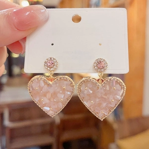 Macro shot of 925 silver post heart earrings with pink crystals and rhinestone border