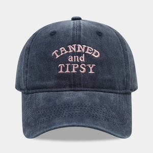Dettaglio del ricamo rosa TANNED AND TIPSY su cappellino da baseball in cotone lavato
