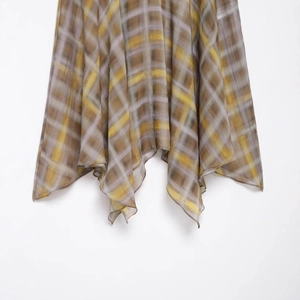 Fashionable plaid midi skirt featuring a lightweight sheer fabric and irregular hemline