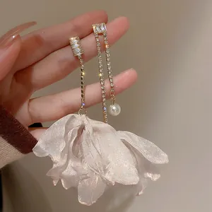Detailed shot of long asymmetric earrings with chiffon pink petals and white pearl drop