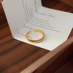 Detailed view of an S925 sterling silver gold-tone ribbed ring on a poetic card