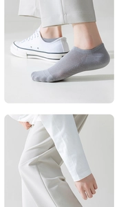 Detail of grey mesh invisible boat socks paired with white canvas shoes for men