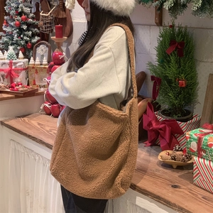Detailed texture of a brown fuzzy teddy plush tote bag in a cozy Christmas setting