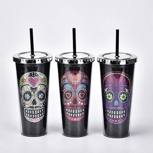 Three black glitter tumblers featuring colorful rhinestone skull designs for Halloween