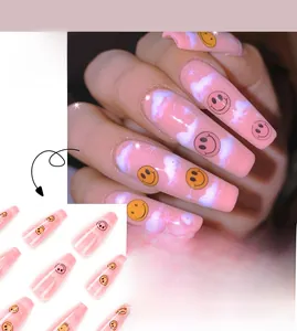 Detail of pink gradient long ballet press-on nails with smiley faces and cloud patterns