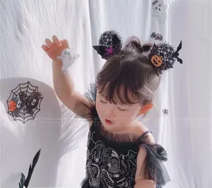 Detail of Halloween hair clips with black lace cat ears, sequins and orange pumpkins