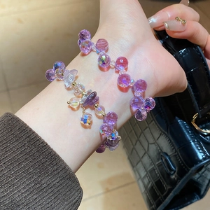 Close-up of faceted purple crystal beaded bracelets with aurora coating and gold accents