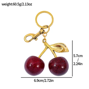 Detail view of cherry keychain with dimensions 6.9x5.7cm and weight 60.5g on white background