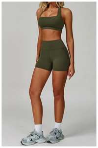 Detailed view of dark olive green sports bra and high-waisted shorts in premium fabric
