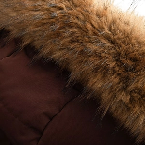 Detail of fluffy faux fur collar and textured dark brown fabric on hooded parka jacket