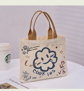 Close-up of canvas tote bag featuring a cute blue cloud illustration and woven handles