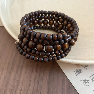 Detailed view of layered coconut shell and wood bead bracelet in vintage ethnic style