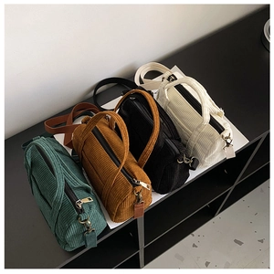 Four colors of vintage corduroy Boston bags arranged diagonally in a studio showcase
