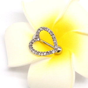 Macro shot of silver heart-shaped belly button ring with sparkling rhinestones on flowers