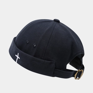 Detail of cross embroidery on black miki hat with adjustable bronze metal buckle