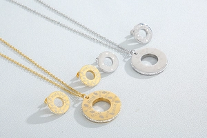 Detailed view of gold and silver MOM heart necklaces and matching rhinestone earrings