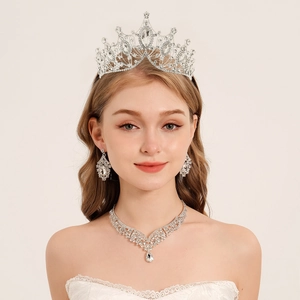 Elegant bridal jewelry set with crystal crown, necklace, and earrings on model