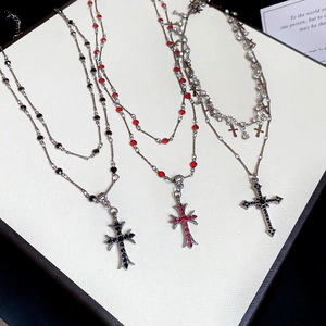 Detail of vintage double-layer cross pendants with red, black and clear zircon stones