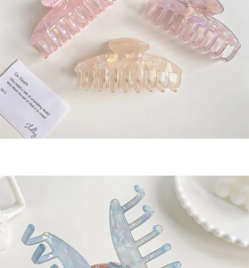 Detail of iridescent hair claw clips showing pearlescent texture and durable plastic teeth