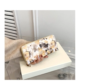 Detail of a marble pattern long wallet for women with golden zipper and luxury finish