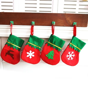 Mini Christmas stockings with reindeer and snowflake patterns hanging on a wooden mantel