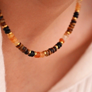 Close-up of a French retro tiger eye stone necklace with colorful beads on a model