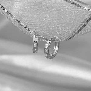 S925 sterling silver diamond-encrusted hoop earrings on a textured ribbon display