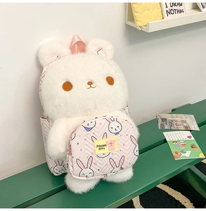 Close-up of white plush bunny backpack featuring a soft fuzzy texture and cute pink front pocket