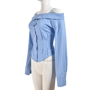 Detail of light blue striped off-the-shoulder shirt with button front and pleated waist