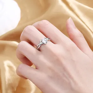 Detail of a sparkling heart zircon ring on a hand with cross-arm silver metal setting