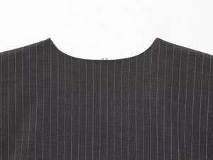 Close-up detail of the round neckline and textured vertical striped fabric on the vest