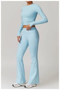 Détails d'un ensemble de yoga bleu clair avec haut court à manches longues et pantalon évasé